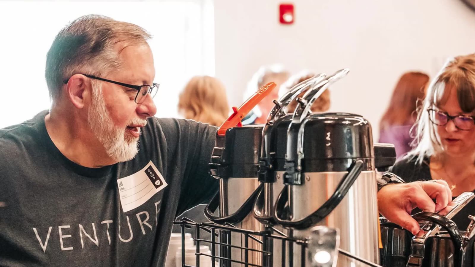 A greeter pouring coffee for guests
